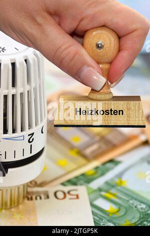 Termostato di riscaldamento, banconote e francobollo 'costi di riscaldamento, Heizkosten', aumento dei costi di riscaldamento Foto Stock