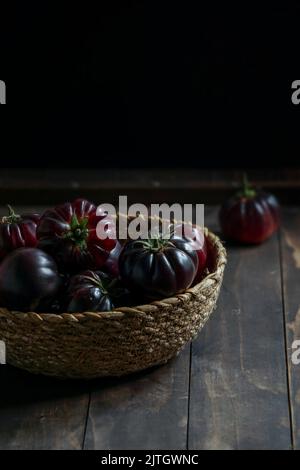 pomodori viola in un cestino di vimini Foto Stock