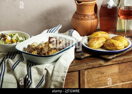 Costolette di maiale al forno con cipolle, patate al forno, vita morta rurale, stile Cottagecore Foto Stock