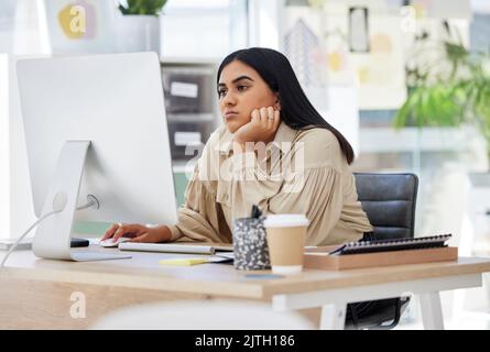 Un dipendente annoiato, pigro e stanco che lavora su un computer in ufficio appoggiandosi alla sua scrivania. Una donna di affari sovraccarica è infastidita e frustrata vicino Foto Stock