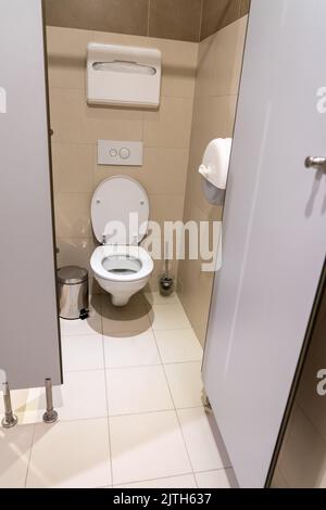 Pulire l'armadio del gabinetto vuoto con la porta aperta nel bagno pubblico Foto Stock