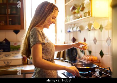 Impaccando su su su su di una certa proteina. Una giovane donna attraente che cucina nel paese. Foto Stock