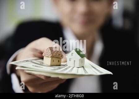 Uomo d'affari mostra denaro nota banca fare un invito piano finanziario persone per vendere o acquistare casa e auto - monetaria proprietà credito di prestito di assicurazione concetto Foto Stock