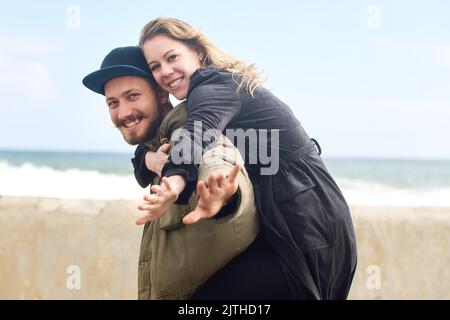 Ammalata la porta fino alle estremità della terra. Ritratto di una giovane coppia affettuosa che trascorre il tempo insieme all'aperto. Foto Stock