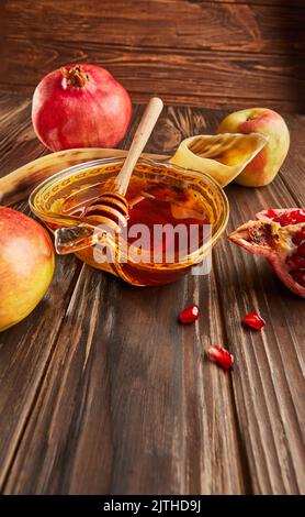Rosh hashanah - concetto ebraico di vacanza di nuovo anno. Ciotola a forma di mela con miele, mele, melograni, shofar su fondo di legno d'annata Foto Stock