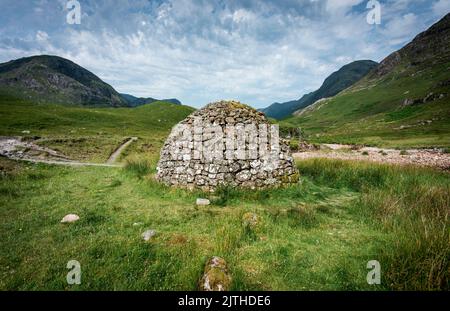 Bella costruzione a forma di cupola, costruita da pietre vicine, una volta utilizzato come bare per le persone della Scozia antica, seduto tra verde erba estiva di Foto Stock