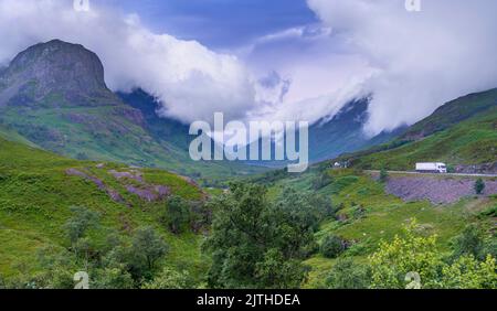 Le nuvole del tramonto in prima serata si avvolgiano rapidamente, la strada principale passa lungo la bellissima valle verde di Glencoe, durante l'estate il paesaggio è Foto Stock