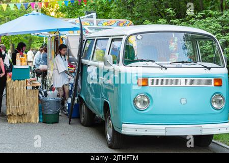 Il furgone Blue VW food serve caffè caldo fresco e cibi prelibati. Tomsk, Russia, 27 maggio 2022 Classic Blue and white VW camper van in vendita foo Foto Stock