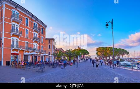 DESENZANO DEL GARDA, ITALIA - 10 APRILE 2022: Il panorama serale dell'argine pedonale del Lungolago Cesare Battisti del Lago di Garda, il 10 aprile Foto Stock