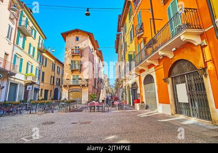 La vecchia e stretta Via Vicolo due Torri con case colorate, piccoli caffè all'aperto, negozi e vicoli minuscoli, Brescia, Italia Foto Stock