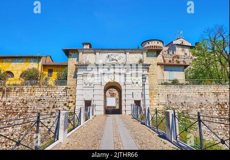 Il Castello medievale di Brescia con mura in pietra, bastioni, torri, fossato profondo, passerella (Via del Castello) e bella porta in pietra con Foto Stock