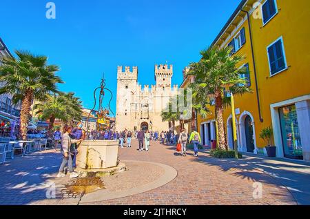 SIRMIONE, ITALIA - 10 APRILE 2022: Piazza Castello con l'Antico Pozzo e il Castello Scaligero medievale sullo sfondo, su Apri Foto Stock