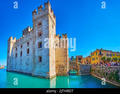 BRESCIA, ITALIA - 10 APRILE 2022: Le alte torri e i bastioni conservati del Castello Scaligero medievale, circondato da fossato e case di città vecchia, su Un Foto Stock