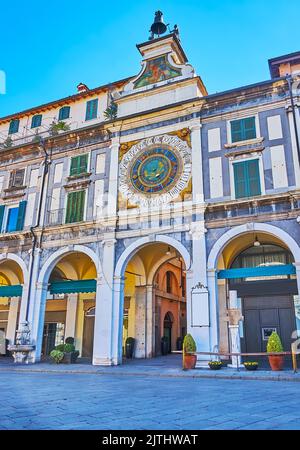 Il passo ad arco sotto la Torre medievale dell'Orologio con orologio astronomico affrescato, Brescia, Lombardia, Italia Foto Stock