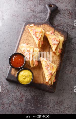 Pane croccante fritto con salsiccia e formaggio fuso closeup nel legno tavola. Vista verticale dall'alto Foto Stock