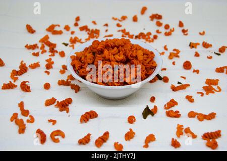 Maccheroni piccanti e saporiti in una ciotola su fondo bianco. I maccheroni secchi hanno una sensazione diversa quando vengono consumati come snack. Foto Stock