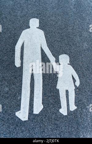 Immagine di un cartello o di un simbolo per i pedoni sulla strada piastrellata Foto Stock