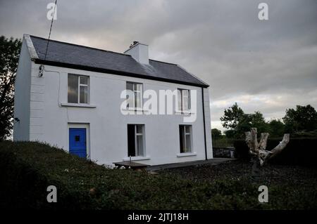 Tradizionale fattoria a due piani imbiancata di bianco, l'Irlanda Foto Stock