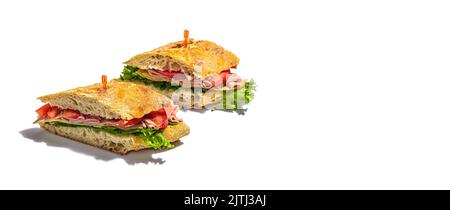 Panini sandwich con prosciutto, insalata croccante e verdure isolate su fondo bianco. Cibo sano per andare concetto, pranzo o opzione snack. Lig duro trendy Foto Stock