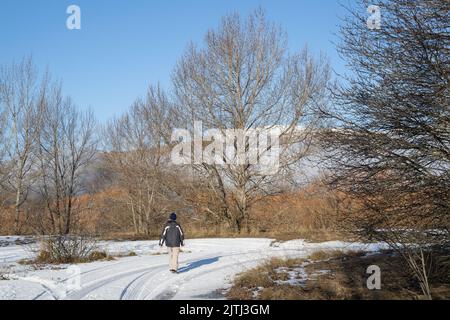 Uomo che cammina sul terreno innevato, Twizel, South Island. Foto Stock