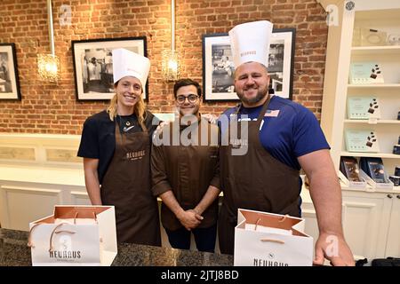 Bruxelles (Belgio), 31 agosto 2022. Noor Vidts, Joe Kovacs e Alim Jetha (C), il maestro di cioccolato belga, si mettono in posa per il fotografo durante un laboratorio di cioccolato presso il negozio di cioccolato Neuhaus, in vista della riunione di atletica della Memorial Van Damme Diamond League, che si terrà mercoledì 31 agosto 2022 a Bruxelles. La riunione della Diamond League si svolge il 02 settembre. FOTO DI BELGA ERIC LALMAND Foto Stock