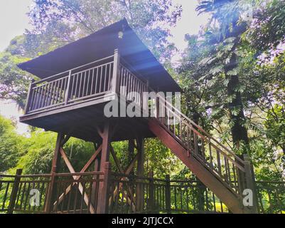 Un bel gazebo nascosto nell'angolo di un cortile, ponte in legno. Il ponte è circondato da un cancello in legno con un disegno a traliccio. Foto Stock