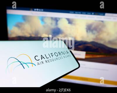 Telefono cellulare con il logo del California Air Resources Board (CARB) sullo schermo di fronte al sito web. Messa a fuoco al centro del display del telefono. Foto Stock