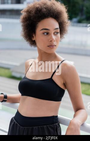 Ritratto dello sportivo afro-americano in cima nera vicino alla ringhiera dello stadio Foto Stock