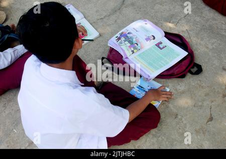 Cianjur, GIAVA OCCIDENTALE, Indonesia. 29th ago, 2022. Gli studenti delle scuole elementari studiano sotto un albero perché la loro classe è quasi crollata nel villaggio di Sukagalih, Cikalong Kulon, Cianjur, Giava Occidentale, il 30 agosto, 2022. La condizione della scuola è stata costretta a studiare sotto gli alberi e in una sala di preghiera perché le tre classi scolastiche sono quasi crollate in modo da non poter essere utilizzate per attività di insegnamento e apprendimento. Tali condizioni non impediscono agli studenti e agli insegnanti di svolgere attività didattiche complete. Sono passati quasi 6 anni da quando l'edificio scolastico non è stato riparato e il Foto Stock