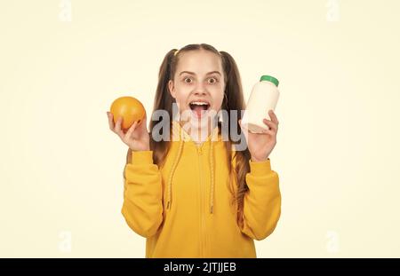 sorprendo ragazza teen scegliere tra frutta d'arancia e pillola di vitamina in vaso bottiglia, nutrizione sana. Foto Stock