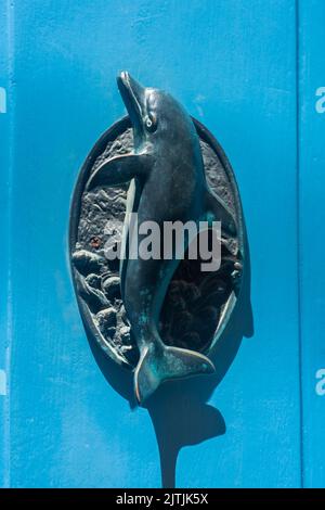 Tipica porta in ottone per delfino bussata su una porta blu a Gozo, Malta Foto Stock