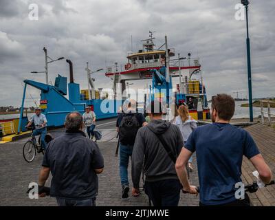 Hoek Van Holland, Paesi Bassi. 27th ago, 2022. Si vedono persone che aspettano di prendere il traghetto. La spiaggia di Hoek van Holland è larga 250 metri e lunga 3,5 km e si trova nell'angolo sud-occidentale dell'Olanda, da qui il nome. Dietro di loro si trovano le dune con piste ciclabili ed escursionistiche liberamente accessibili. Durante la seconda guerra mondiale, The Hook fu uno dei luoghi più importanti per la Wehrmacht a causa del suo porto, che costituiva una parte importante e strategica del Muro Atlantico. A causa del bel tempo di questo fine settimana, i cittadini olandesi e i turisti stranieri potrebbero godersi la spiaggia camminando, nuotando, un Foto Stock