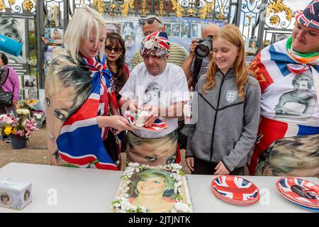 Kensington Palace, Londra, 31st agosto 2022. I fan reali, Maria Scott, John Loughrey, il vincitore del Diana Legacy Award, Olivia Hancock e Patrick o'Neil, si riuniscono a Kensington Palace Gates per tagliare una torta commemorativa del £200 in occasione del 25th° anniversario della morte di Diana, Principessa del Galles. La principessa è stata uccisa in un incidente d'auto a Parigi in questo giorno nel 1997. Amanda Rose/Alamy Live News Foto Stock