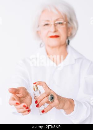 signora anziana lifestyle fragranza scelta costosa Foto Stock