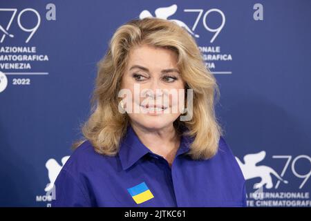 Lido di Venezia, Italia. 31st ago, 2022. L'attrice francese Catherine Deneuve, che indossa una bandiera dell'Ucraina sulla sua maglia, posa il 31 agosto 2022, durante una fotocall per il Leone d'oro per il conseguimento a vita, sarà premiata, il giorno di apertura del 79th° Festival Internazionale del Cinema di Venezia al Lido di Venezia. © Photo: Cinzia Camela. Credit: Independent Photo Agency/Alamy Live News Foto Stock