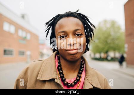 Ritratto giovane donna sorridente con capelli intrecciati sulla strada Foto Stock