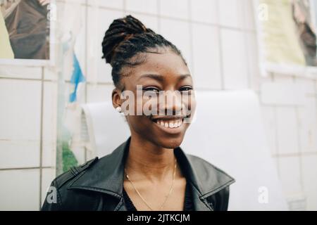 Ritratto di felice giovane donna di fronte al muro Foto Stock
