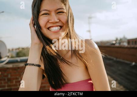 Ritratto di felice giovane donna sul tetto Foto Stock
