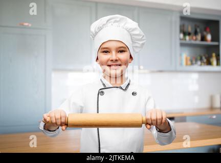 ragazzo sorridente in toque dello chef con spilla Foto Stock