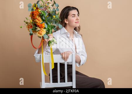 ritratto di donna con fiori seduti sulla sedia Foto Stock