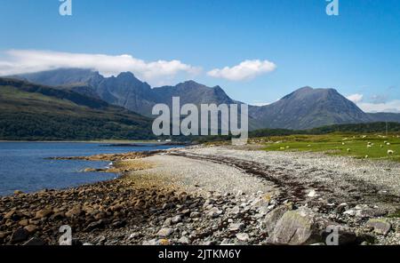 Vista costiera del lago Slapin sull'isola scozzese di Skye in una giornata di sole con le montagne sullo sfondo. Foto Stock