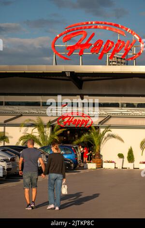 Felice coppia a piedi verso il ristorante Happy Bar and Grill a Sofia, Bulgaria, Europa orientale, UE Foto Stock