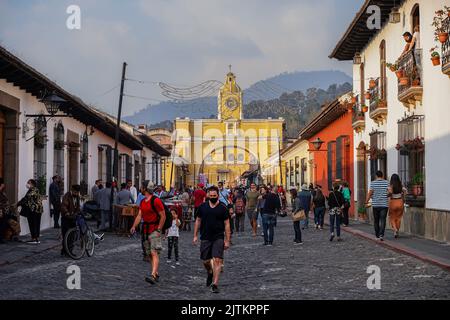 Bellissima ripresa aerea cinematografica della città di Antigua in Guatemala, la sua chiesa gialla, l'Arco di Santa Catalina e il vulcano Acatenango Foto Stock