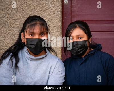 Viacha, la Paz, Bolivia - Agosto 16 2022: Due Sorelle che indossano una maschera nera Guarda la fotocamera Foto Stock