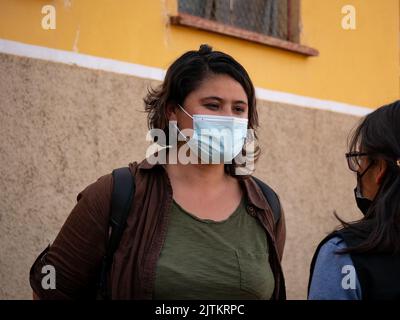 Viacha, la Paz, Bolivia - Agosto 16 2022: Una donna boliviana che indossa una maschera parla con un'altra donna fuori casa Foto Stock