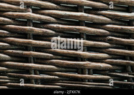 Primo piano con struttura in vimini. Ramoscelli marroni rotondi piegati l'uno intorno all'altro. Alcuni orizzonti, ma più verticali. Foto Stock