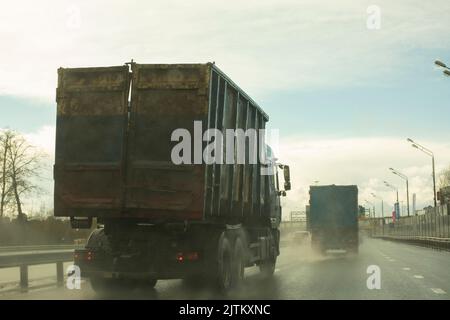 Veicolo per raccolta rifiuti su strada. Il carrello sta percorrendo l'autostrada. Immondizia può in auto. Trasporto di rifiuti. Foto Stock