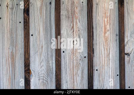 Parete in legno a due strati realizzata con tavole bianche e scure. Struttura rustica. Teste delle viti visibili. Sottili strisce scure tra quelle chiare spesse. Foto Stock