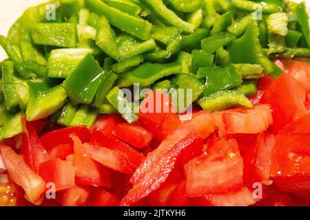 Peperoni verdi e pomodori tritati su un tavolo in Brasile. Foto Stock