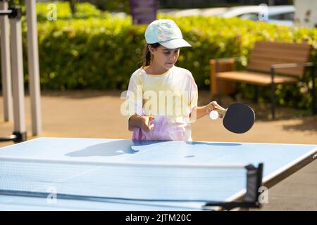 Bambina che gioca a ping pong nel parco. Foto Stock